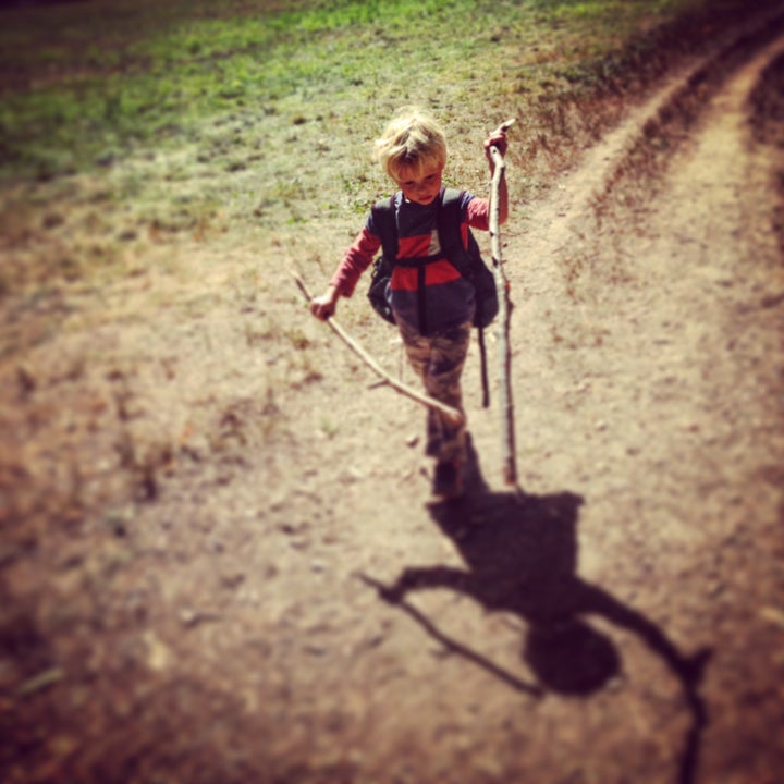 Junior wanders the woods with a set of walking sticks.