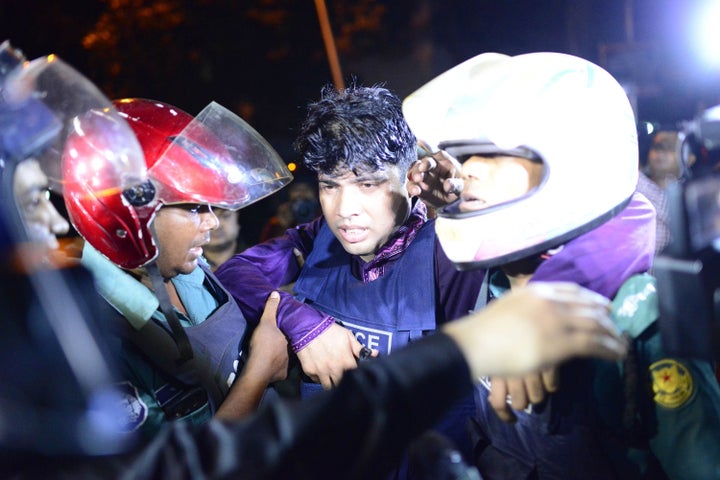 An injured Bangladeshi policeman being assisted after a granade attack at a restaurant nearby in the early hours of July 2, 2