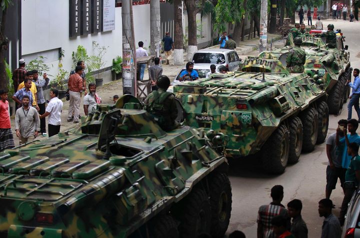 Armored vehicles pass by after an operation against militants who took hostages at a restaurant popular with foreigners in Dhaka, Bangladesh, Saturday, July 2, 2016.