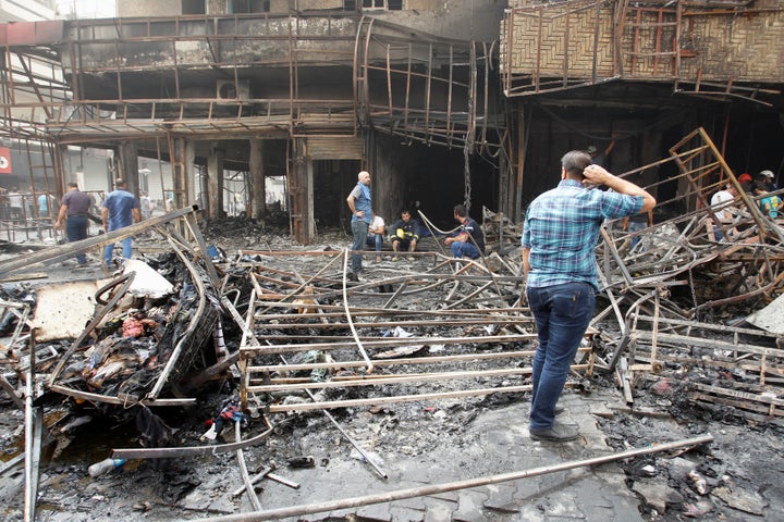 Iraqi security forces and civilians gather at the site after a suicide car bomb occurred in the Karrada shopping area in Bagh