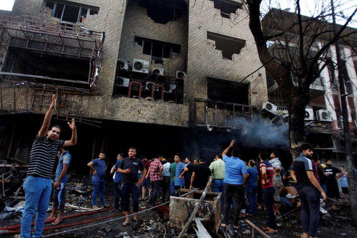 People gather at the site of a suicide car bomb in the Karrada shopping area, in Baghdad, Iraq July 3, 2016.