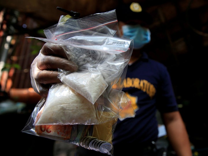 A member of the Philippine National Police (PNP) investigation unit shows confiscated methamphetamine, known locally as Shabu
