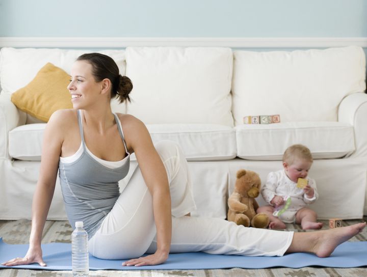 Mother practicing yoga next to baby on floor Tetra Images - Jamie Grill via Getty Images