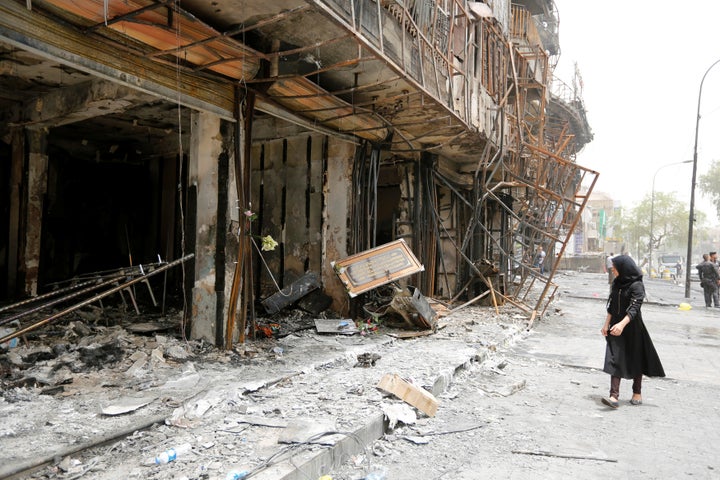 A girl walks past the site after a suicide car bomb attack at the shopping area of Karrada, a largely Shi'ite district, in Ba