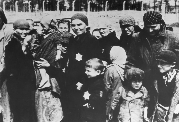 Jewish women and children, some wearing the yellow Star of David patch on their chests, at the Auschwitz concentration camp.