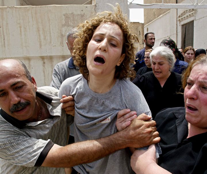 The mother of Rami Saad, 4, and Sami Saad, 6, cries out during the funeral of her two children who died the day before in a mortar attack that hit their house situated near a Baghdad hotel complex, 10 July 2004 at a Chaldean church in Baghdad. Three other people were wounded when mortars hammered into a house behind the capital's Sadeer hotel often used by foreigners.