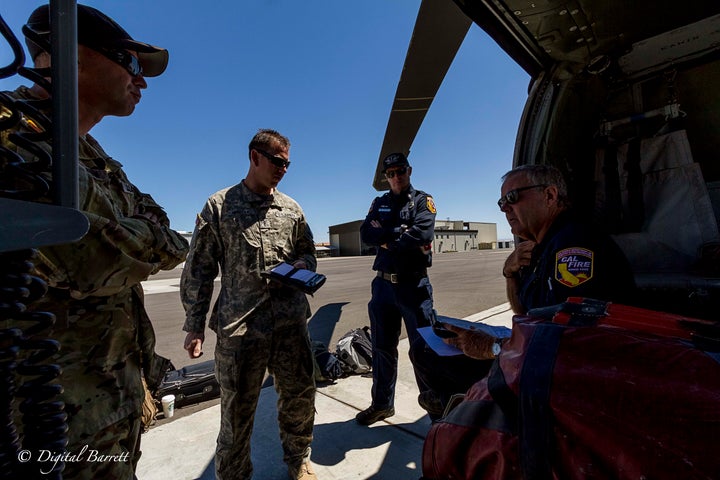 Chief Warrant Officer 3 Scott St. Aubin, Chief Warrant Officer Jon Herrera, Fire Captain Eric McGuire, and Cal Fire Military Helicopter Manager Chief Mike Harkness have a crew briefing before taking to the air.