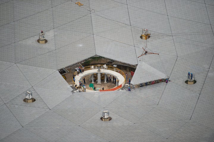 Workers lift the last panel to install into the center of a Five-hundred-meter Aperture Spherical Telescope (FAST) on July 3.