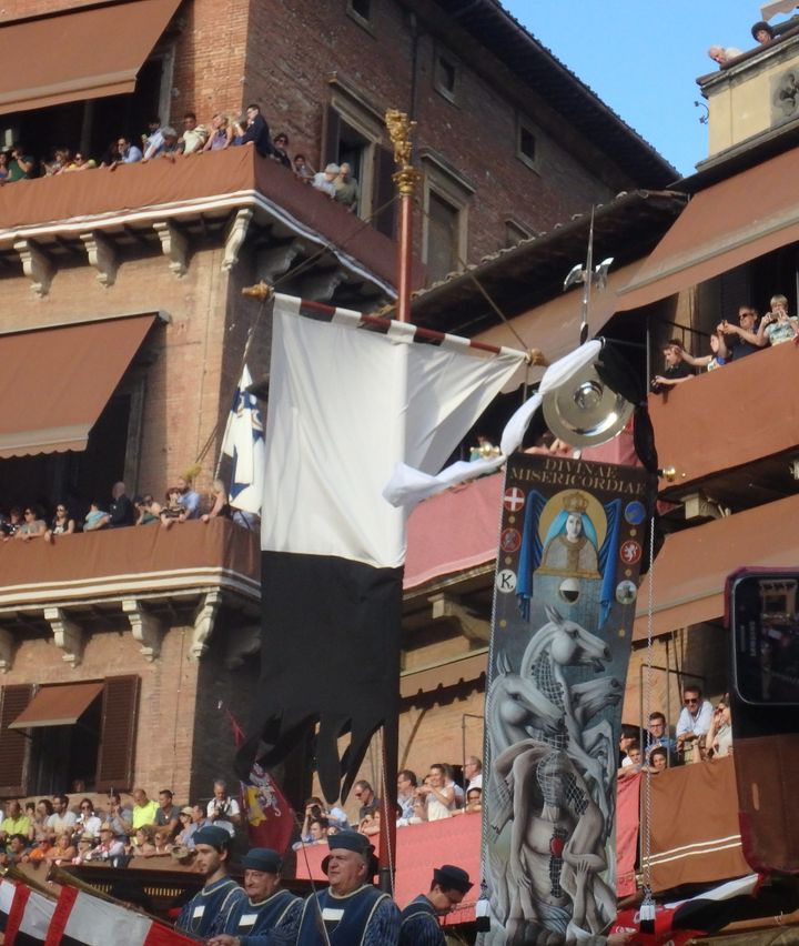 The Palio banner, right, makes it way around the Piazza del Campo in Siena. All the contrada members wave their fazzoletti (scarves) as it passes in front of them. 