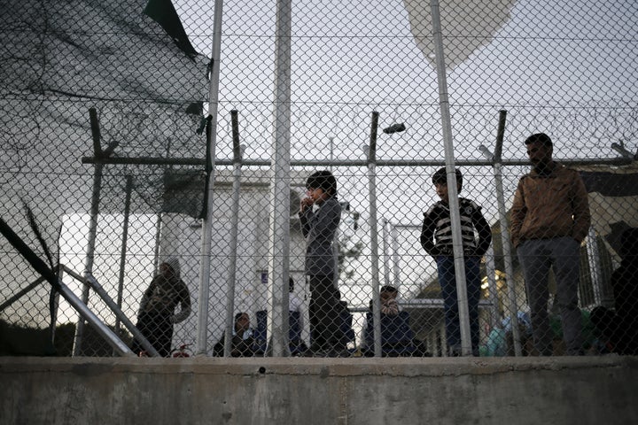 A migrant child stands next to a metal fence at the Moria refugee camp on the Greek island of Lesbos on November 5, 2015. The