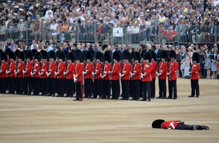 A soldier collapses on Horse Guards Parade ahead of the Queen's Birthday Parade, 'Trooping the Colour', in London on June 11, 2016.