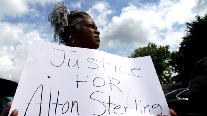 Ivy Early Thomas holds a sign while mourning the death of Alton Sterling, a 37-year-old father of five who was killed by Baton Rouge police officers.