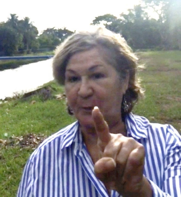 Maria Dorrbecker waves her finger at Rayne Burse, an African American woman walking her dog in her new neighborhood.