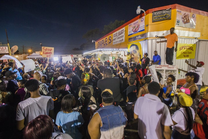 Protesters gather in front of the convenience store where Alton Sterling was shot and killed, July 6, 2016 in Baton Rouge, Louisiana.