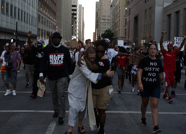 Protesters embrace during a march through downtown Dallas Thursday, July 7. 