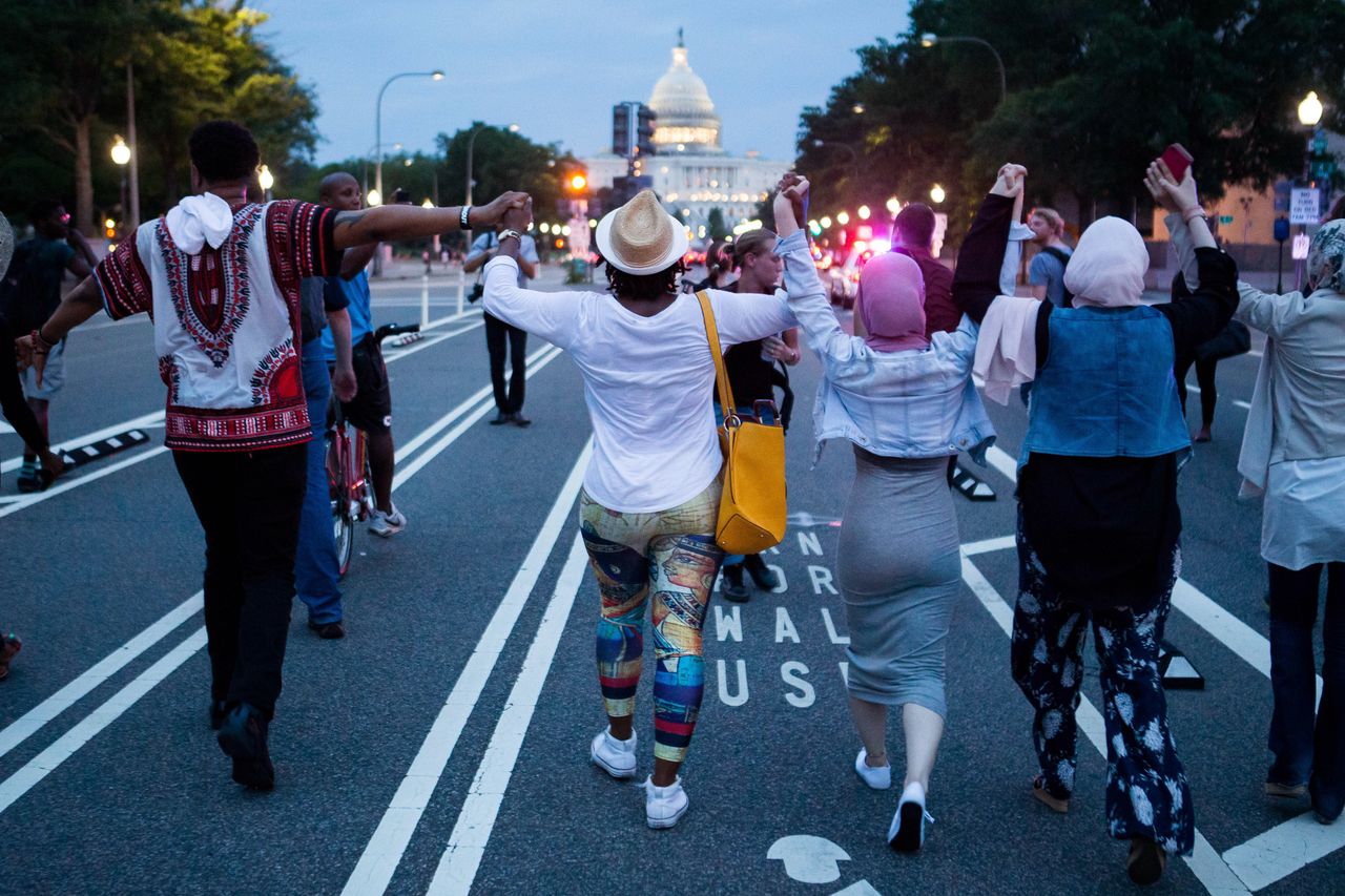 Demonstrators hold hands as they march from The White House to Capitol Hill on July 7, 2016 in Washington, D.C.