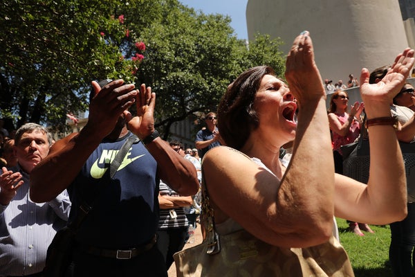 People gather in a prayer vigil following the shooting deaths of five police officers last night during a Black Live Matter m