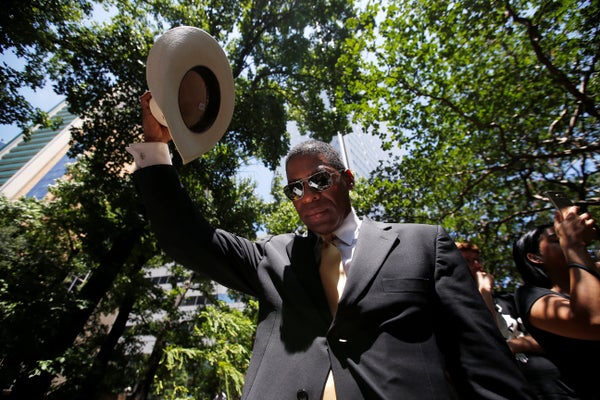 A man raises his hat in prayer during a prayer vigil in a park following the multiple police shooting in Dallas, Texas, U.S.,