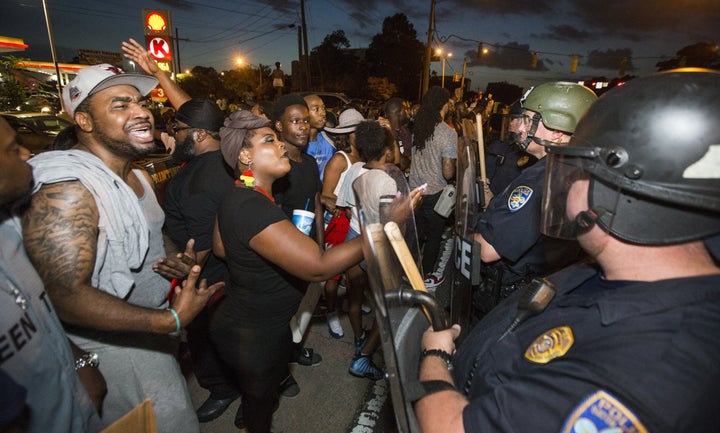 Protesters face off with Baton Rouge police in riot gear across the street from the police department on July 8, 2016 in Bato