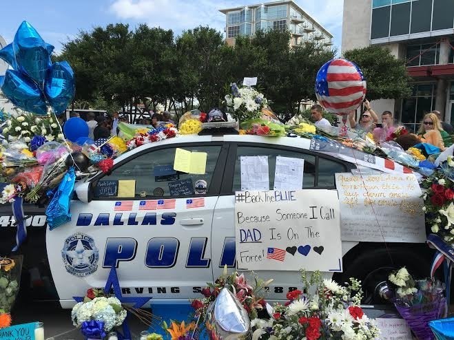 A cop car in Dallas is covered in flowers and messages of love Saturday, July 9, 2016. 