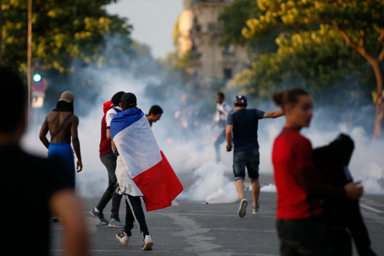 Tear gas floats in the air during clashes near the Paris fans zone during the Portugal v France EURO 2016 final soccer match at the Eiffel Tower in Paris, France.