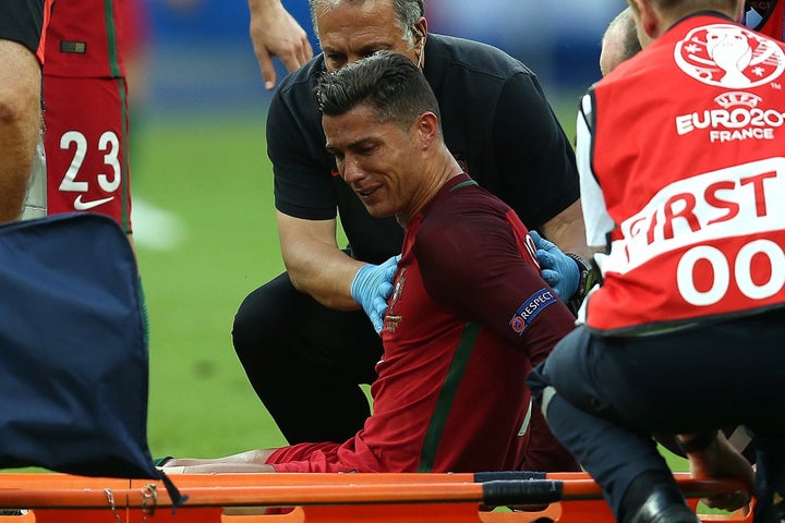 Cristiano Ronaldo of Portugal sheds tears as he waits to be carried off on a stretcher during the UEFA Euro 2016 final match