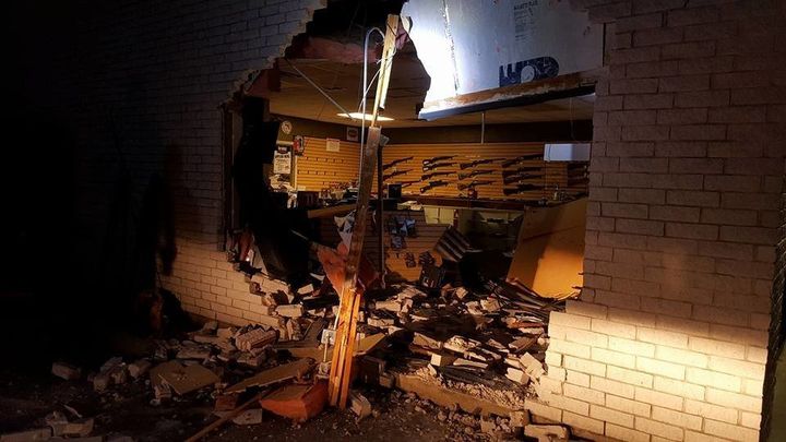 A display of weapons is visible through the rubble left behind by a gun store robbery.