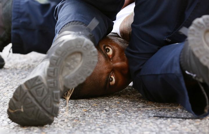 A man protesting Sterling's death is detained by officers near the Baton Rouge Police headquarters. 