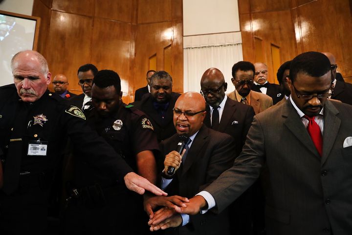Police officers from area departments in and around Dallas pray with Carl Sherman, a pastor and former mayor of DeSoto, Texas, at a multicultural prayer vigil on July 10, 2016 in Dallas, Texas.