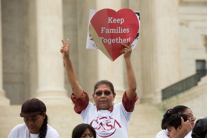 Antonia Surco, originally from Peru, holds a sign in front of the Supreme Court on the day the justices split 4-to-4 on a ruling that would've granted immigrants a reprieve from deportation.