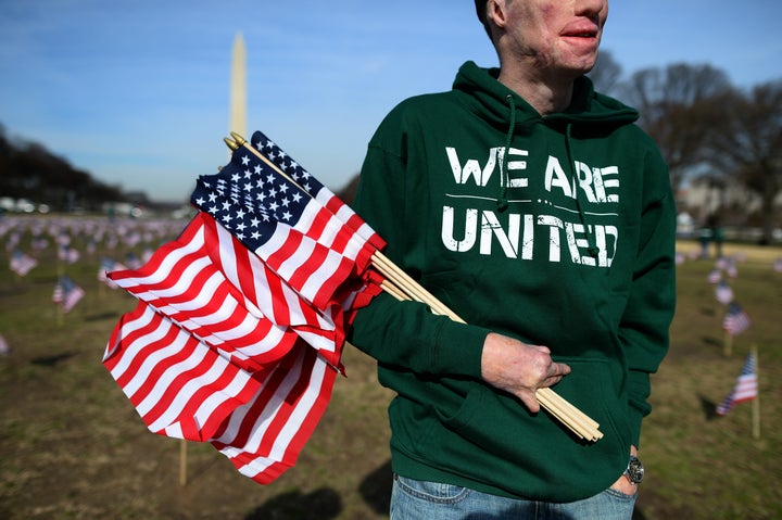 US Marine Corps Cpl. Aaron Mankin helps set up 1,892 American flags on the National Mall in Washington, DC, on March 27, 2014. The Iraq and Afghanistan veterans installed the flags to represent the 1,892 veterans and service members who committed suicide this year as part of the 'We've Got Your Back: IAVA's Campaign to Combat Suicide.' 