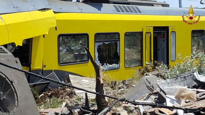 A damaged passenger train is seen after a collision with another in the middle of an olive grove in the southern village of C