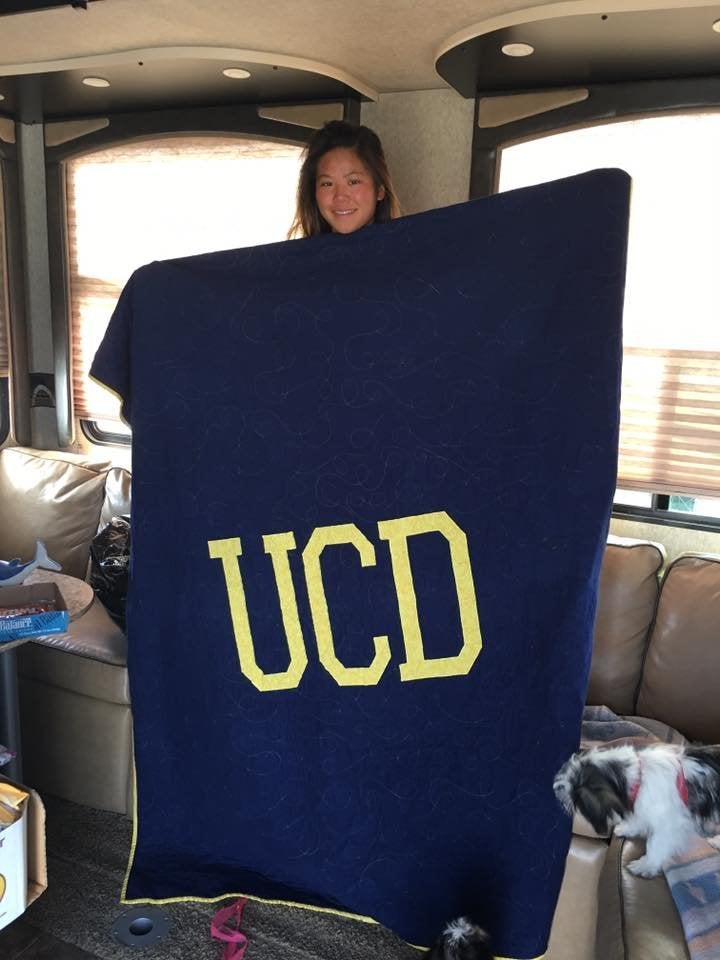 Sulyn Harvey holds up the back side of the memory quilt. She is headed to University of California, Davis.