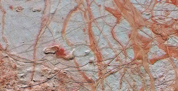 An enhanced color view from NASA's Galileo spacecraft shows an intricate pattern of linear fractures on the icy surface of Jupiter's moon Europa.