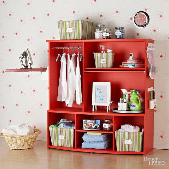 An entertainment center is repurposed as a laundry station.