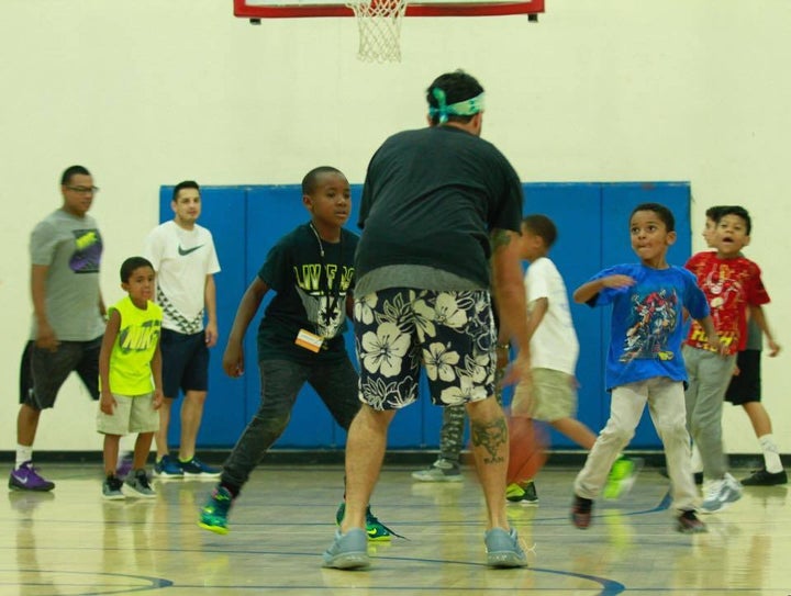 Rikki Mendias playing ball in his old gym with PAL kids