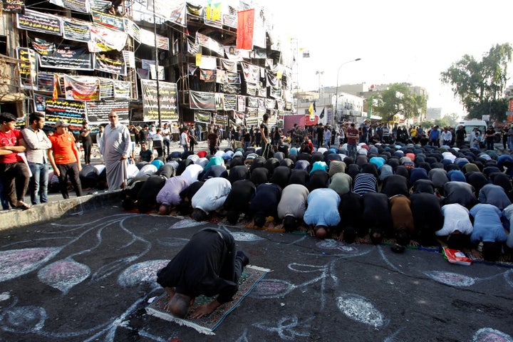 Sunni and Shi'ite Muslims attend prayers in Baghdad on July 6 during Eid al-Fitr as they mark the end of the Muslim holy month of Ramadan, at the site of a suicide car bomb attack claimed by ISIS. Nearly 300 died and 200 left wounded in multiple attacks. 