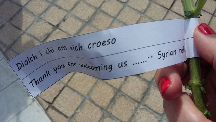 A note handed out with the flowers read 'thank you for welcoming us'