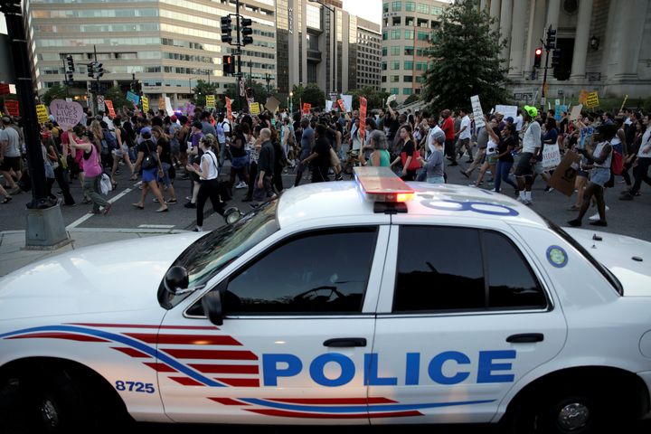 Demonstrators with Black Lives Matter march past a Metropolitan police officer blocking traffic during a protest in Washington, U.S., July 9, 2016.