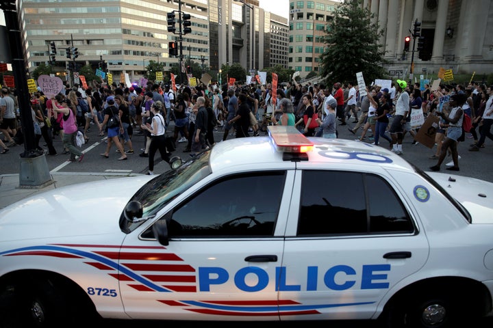 Demonstrators with Black Lives Matter march past a Metropolitan police officer blocking traffic during a protest in Washingto