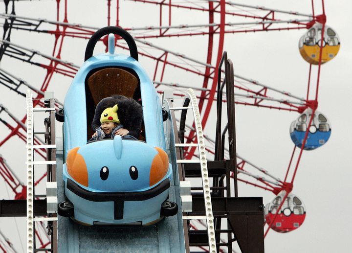 A small child in a Pikachu hat rides a roller coaster that looks like a Mudkip in a 2005 photograph. The Pokemon franchise's popularity has surged again thanks to the new "Pokemon Go" app.