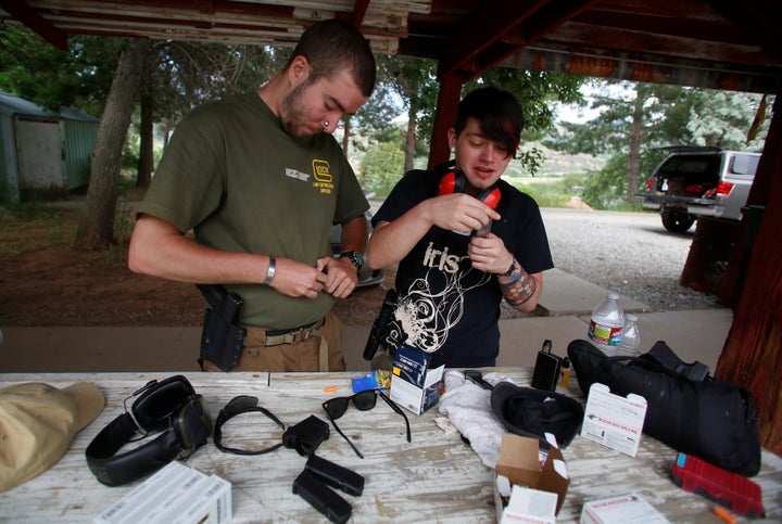 Matt Schlentz (L) and his partner Skylar Simon load magazines of ammunition during a firearms training class attended by memb