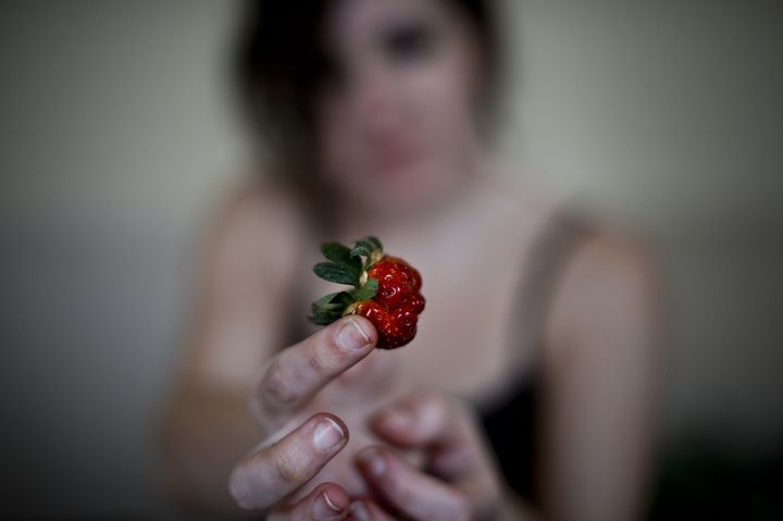 A volunteer shows an 'ugly' strawberry at the 'Fruta Feia' (Ugly Fruit) co-op in Lisbon.