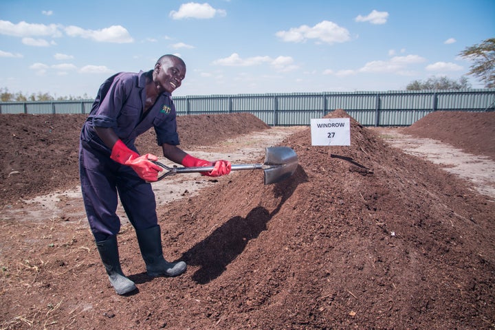 Sanergy employee working with their organic fertilizer made from human waste.