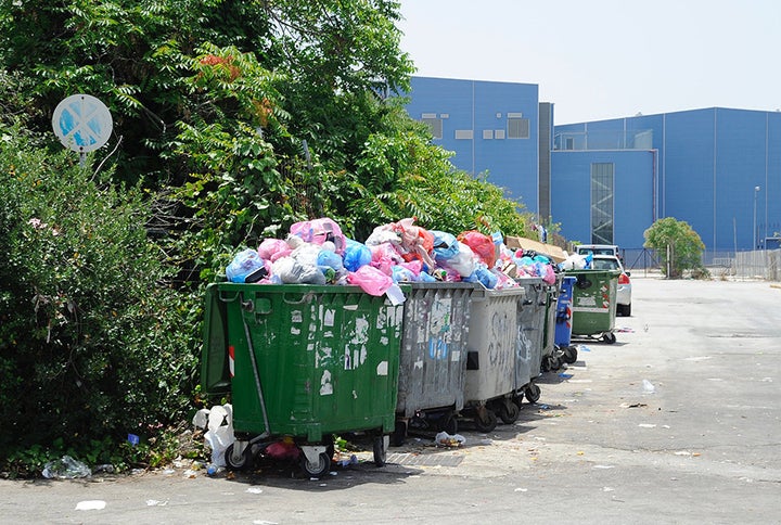 Trash piles up in nearby dumpsters.