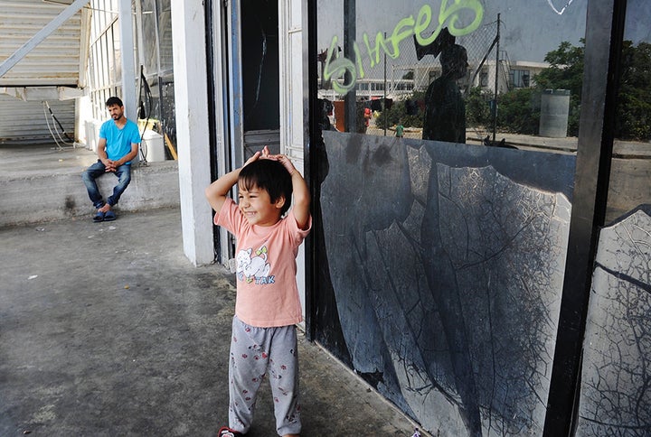 A child whiles away the time out of the sun's glare.