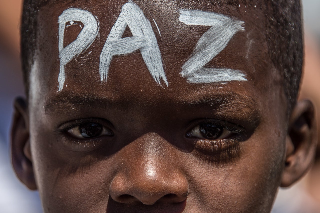 A young Brazilian boy with the word "peace" written on his forehead protests in Rio's Alemao favela, where police shot and killed a 10-year-old while fighting drug gangs last year. A United Nations group has linked Brazilian police to "an elevated number of summary executions of children" ahead of the Olympics.