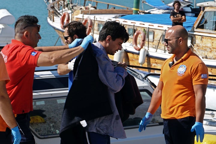 Paramedics escort people who were rescued at sea at the port of Mytilene on the island of Lesbos on July 13, 2016.