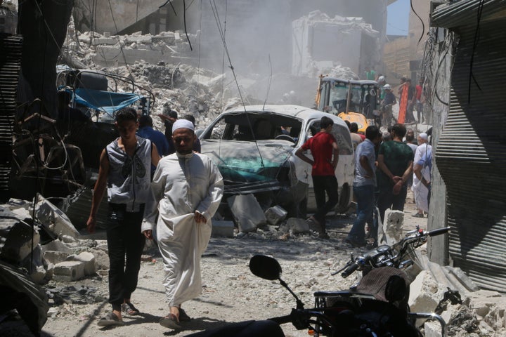 Civilians inspect the damage of a barrel bombing in the Syrian city of Aleppo, north of Damascus. Syrian President Bashar Ass