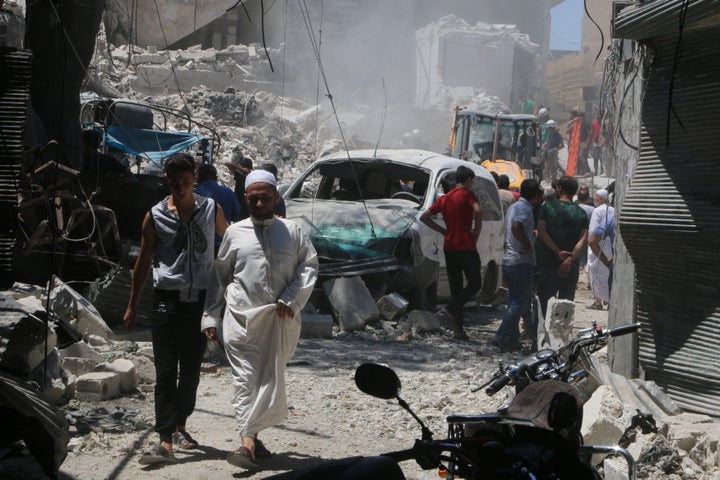 Civilians inspect the damage of a barrel bombing in the Syrian city of Aleppo, north of Damascus. Syrian President Bashar Assad denies that his government uses barrel bombs.